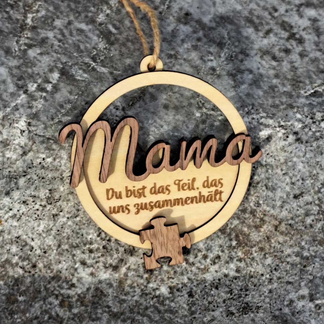 Produkt: Ornament mit Nussholzschriftzug 'Mama' aufgeleimt und graviertem Text 'Du bist das Teil, das uns zusammenhält'